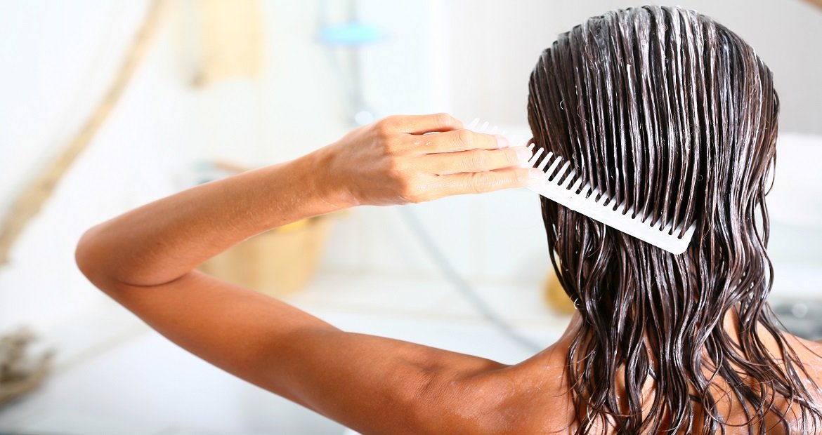 Mulher Com Creme No Cabelo E Passando Pente